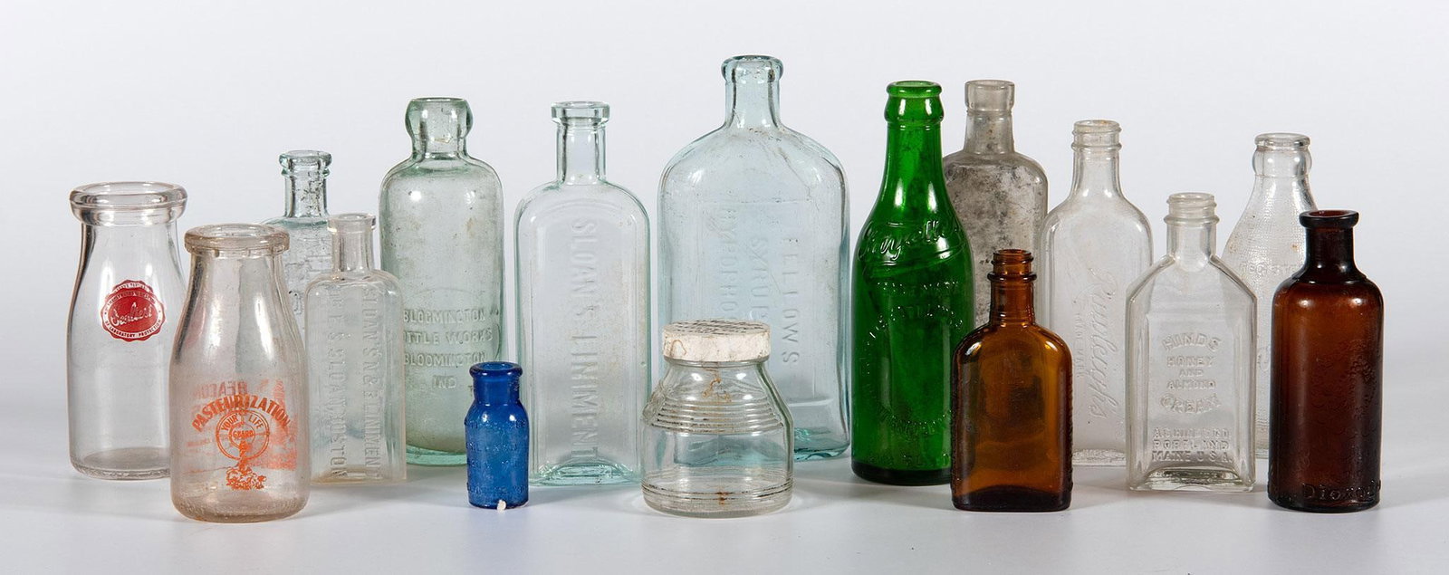 Grouping of 19th & 20th Century American Advertisement Glass Bottles: American, 19th and 20th century. A group of 16 various shape color and sized American glass bottles with numerous makers markings, lot includes Fayette Bottling and Ice Co. California Fig Syrup Co., E