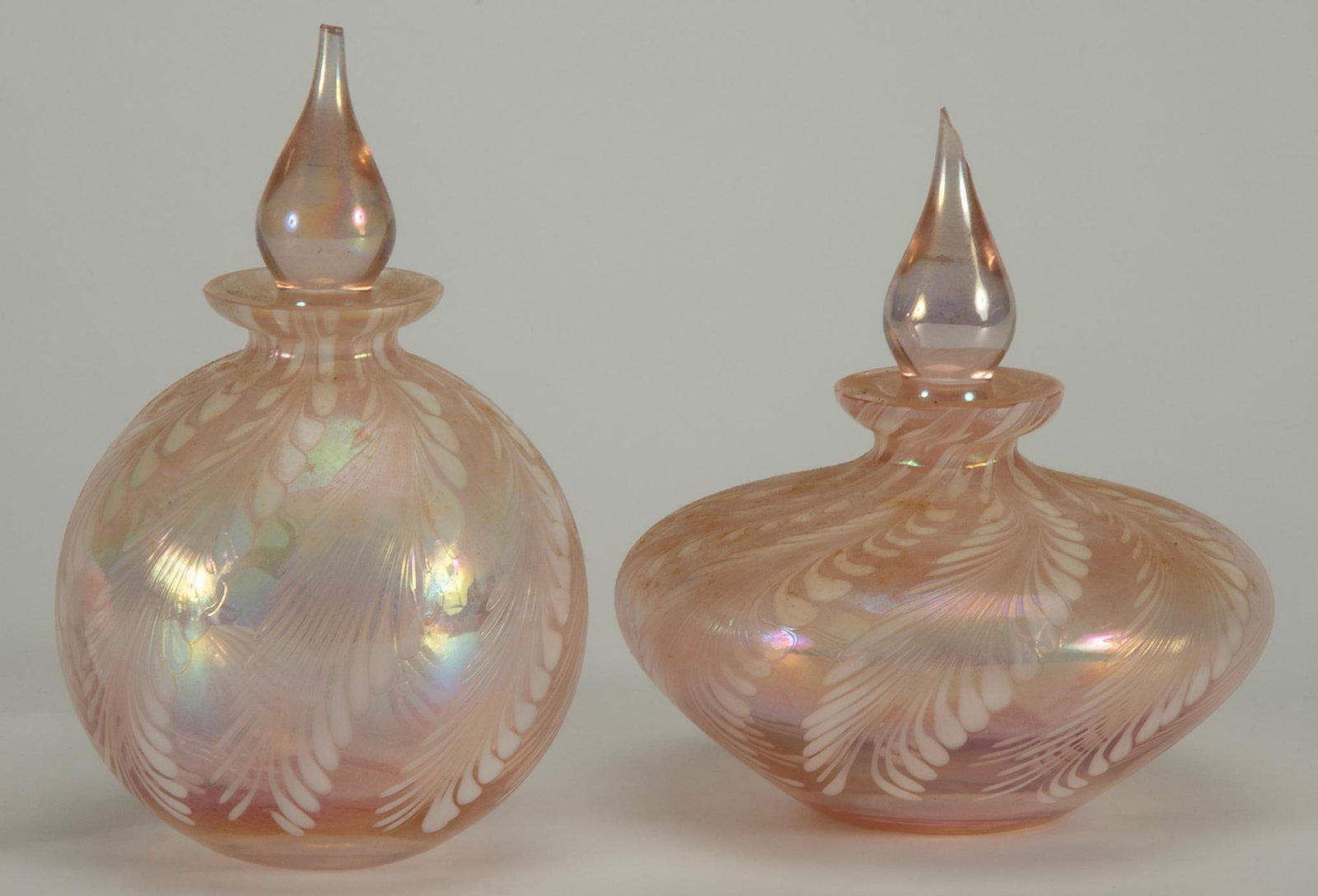 Two Silvestri Pink Iridescent Perfumes: Lot includes two Silvestri Pink Iridescent Perfumes; largest 4.5 x 4 inches. Each with chip loss to the perfume stopper uppermost tip.