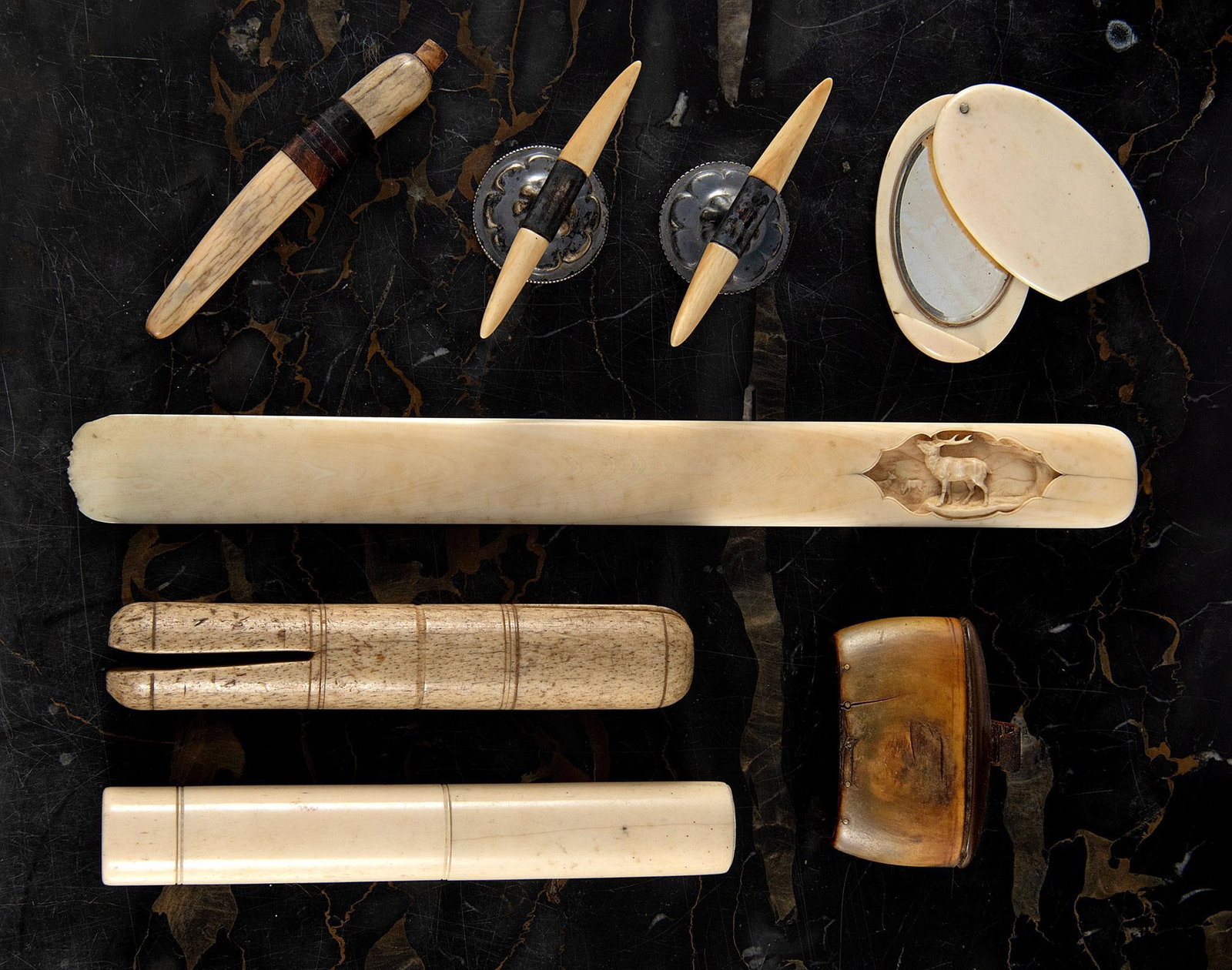 Alaskan Inuit Walrus Tusk Carvings: American, 19th and 20th century. A grouping of walrus tusk inuit tools, lot includes letter opener, mirror, tools, lidded box plus.; largest 12.5 inches. Overall good condition. 8 total items.
