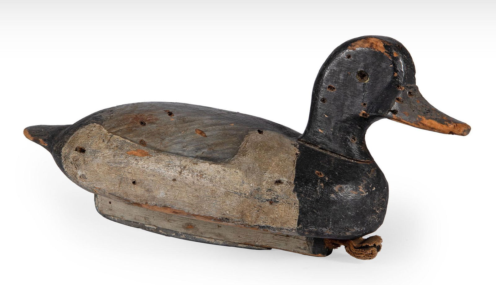 Antique Carved and Painted Duck Decoy: American, 20th century. A carved and painted duck decoy, missing eyes, gunning and paint loss present along with weight; ht. 6, wd. 13.5, dp. 5.25 inches. Overall good condition.