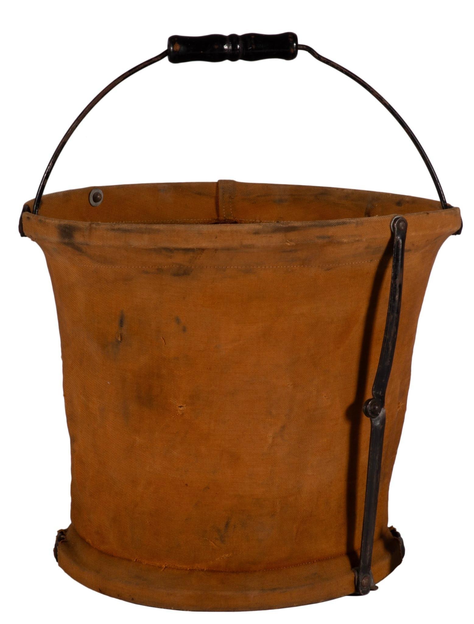 N.Y.C.R.R Brown Canvas Pail Bucket with Handle: American, 19th century canvas pail stamped in black stenciled letters, "N.Y.C.R.R. Handy Folding Pail Co. New York, N.Y." 9" height x 11" diameter at top rim. Black metal handle and hinges and hoops.