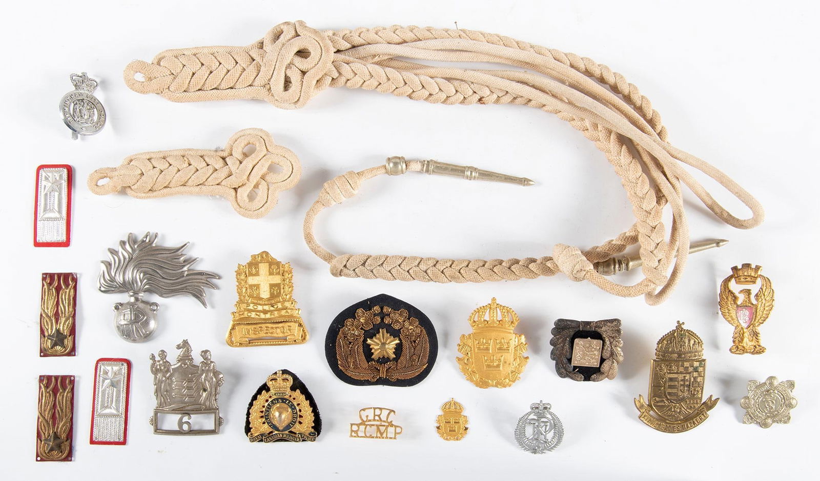 Grouping of Continental Police Badges: Grouping of Continental Police Badges – Includes Badges and Cords. This lot features a selection of continental police badges, accompanied by associated cords. A unique collection, ideal for law enf