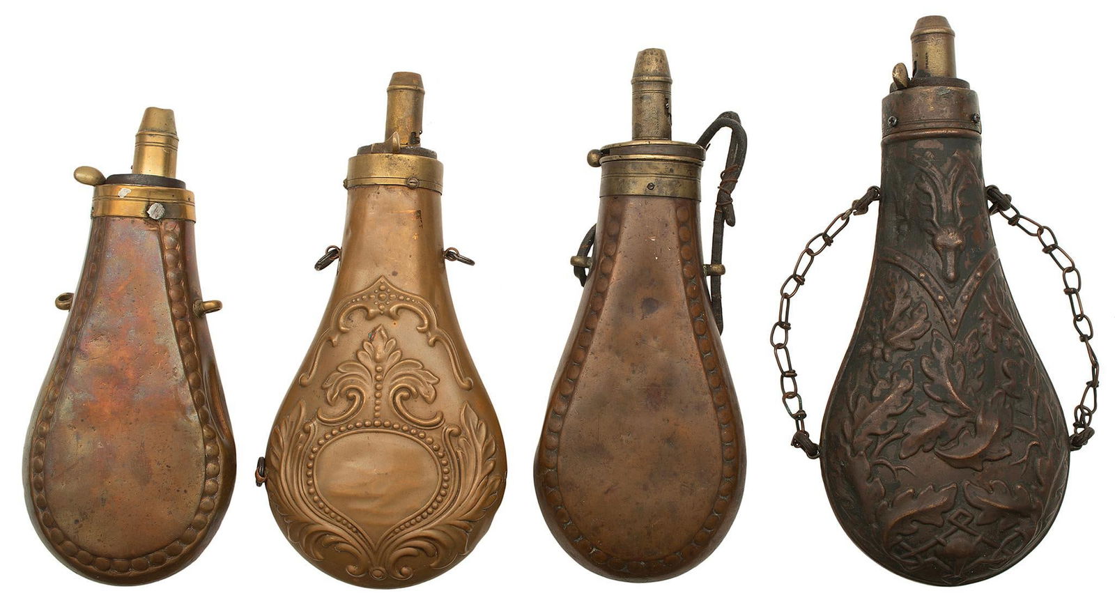 Lot of Four Large Antique Powder Flasks: One with stag and Oak leaf design and adjustable spout. Two with plain bodies and Circle design border and adjustable spout. One with floral designs and adjustable spout. Good to very good condition.