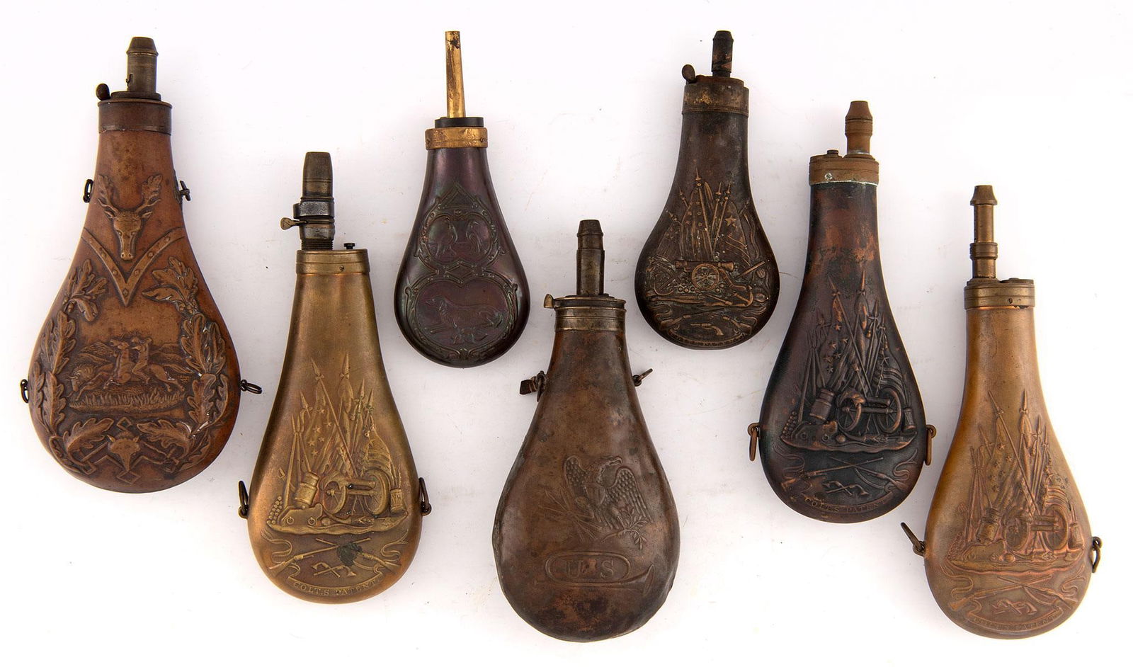 Lot of 7 Scene Powder Flasks: Group of seven powder flasks that includes examples of game and artillery scenes, one (1) marked with eagle and “U.S.”, four (4) marked “Colt’s Patent,” and one (1) Remington reprodu