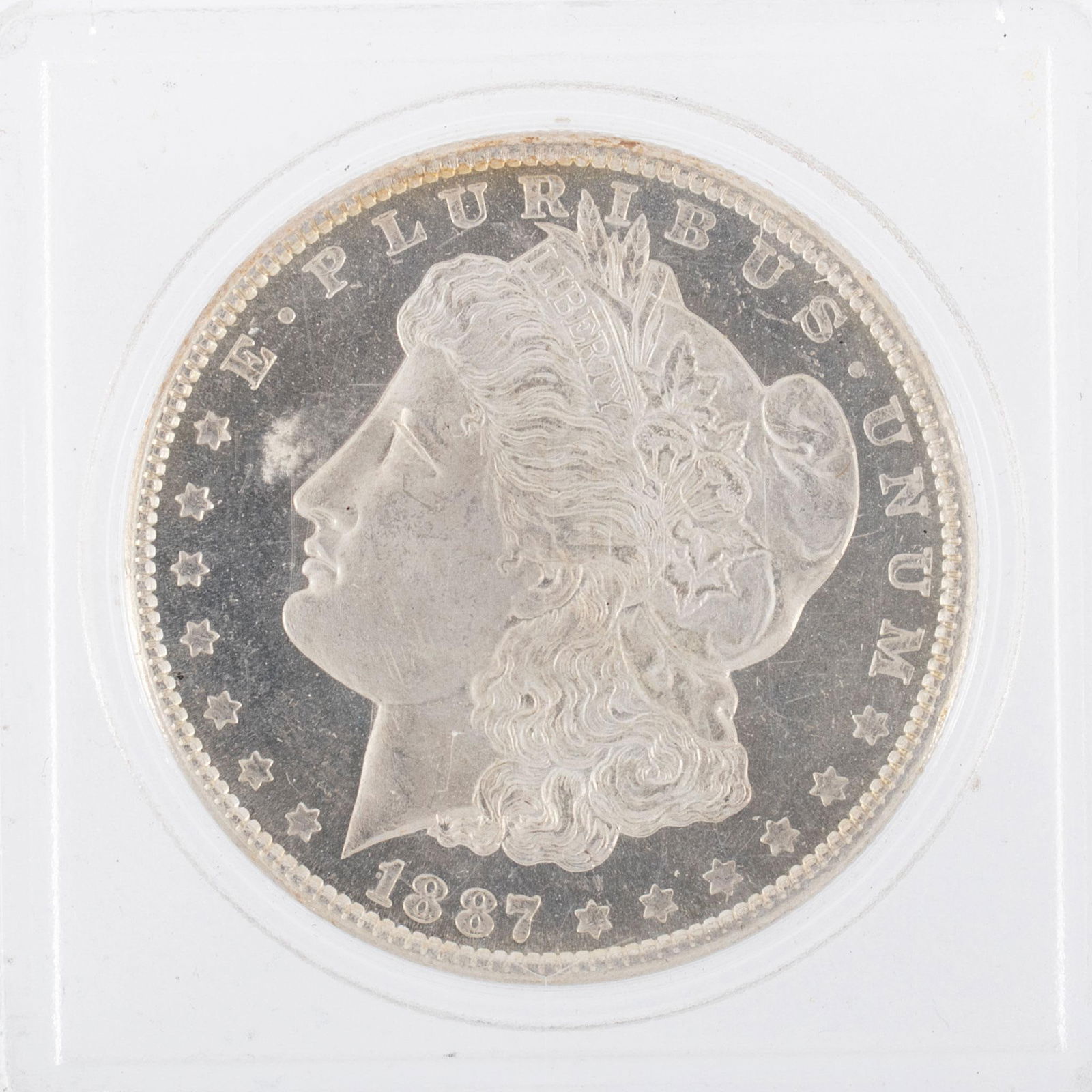 United States 1887 Silver Morgan Dollar Coin: A United States 1887 silver Morgan dollar ungraded coin in case. Very good condition.