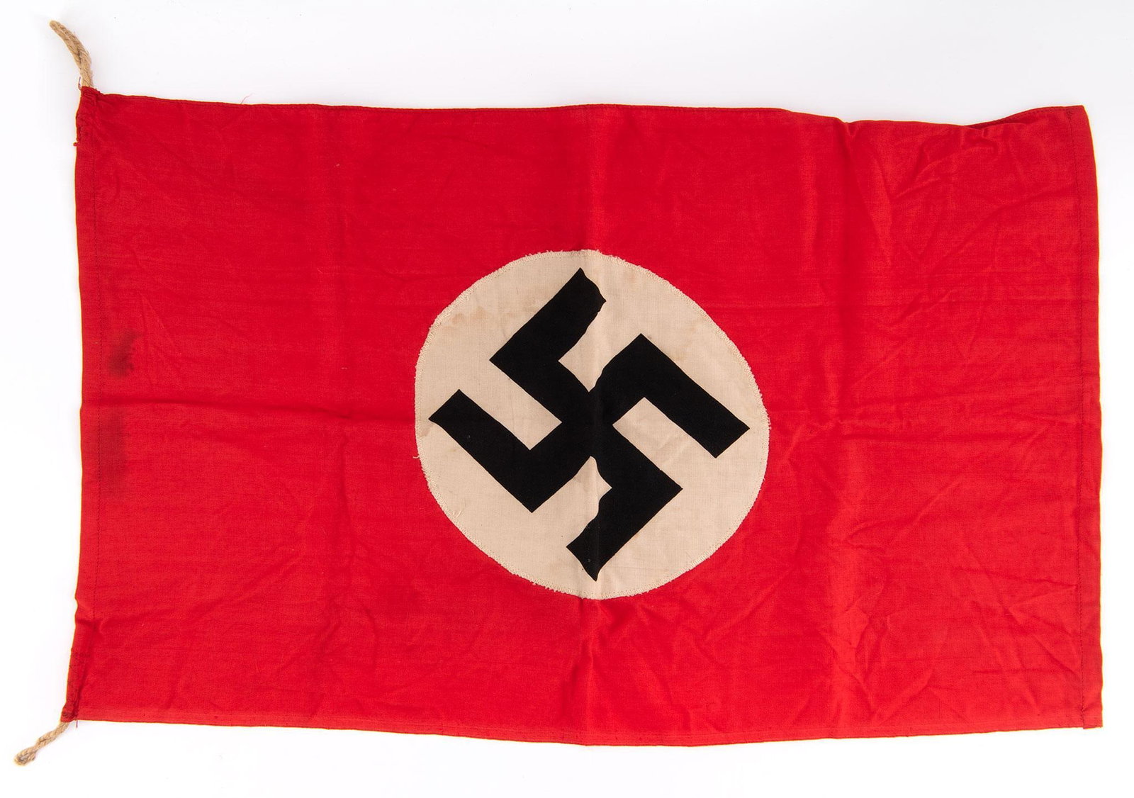 World War II German NSDAP Banner: This banner measures 23" in length by 14" in width. Double sided banner displaying the swastika on each side with hemp hanging rings. Finely stitched throughout with very little wear. Front side near