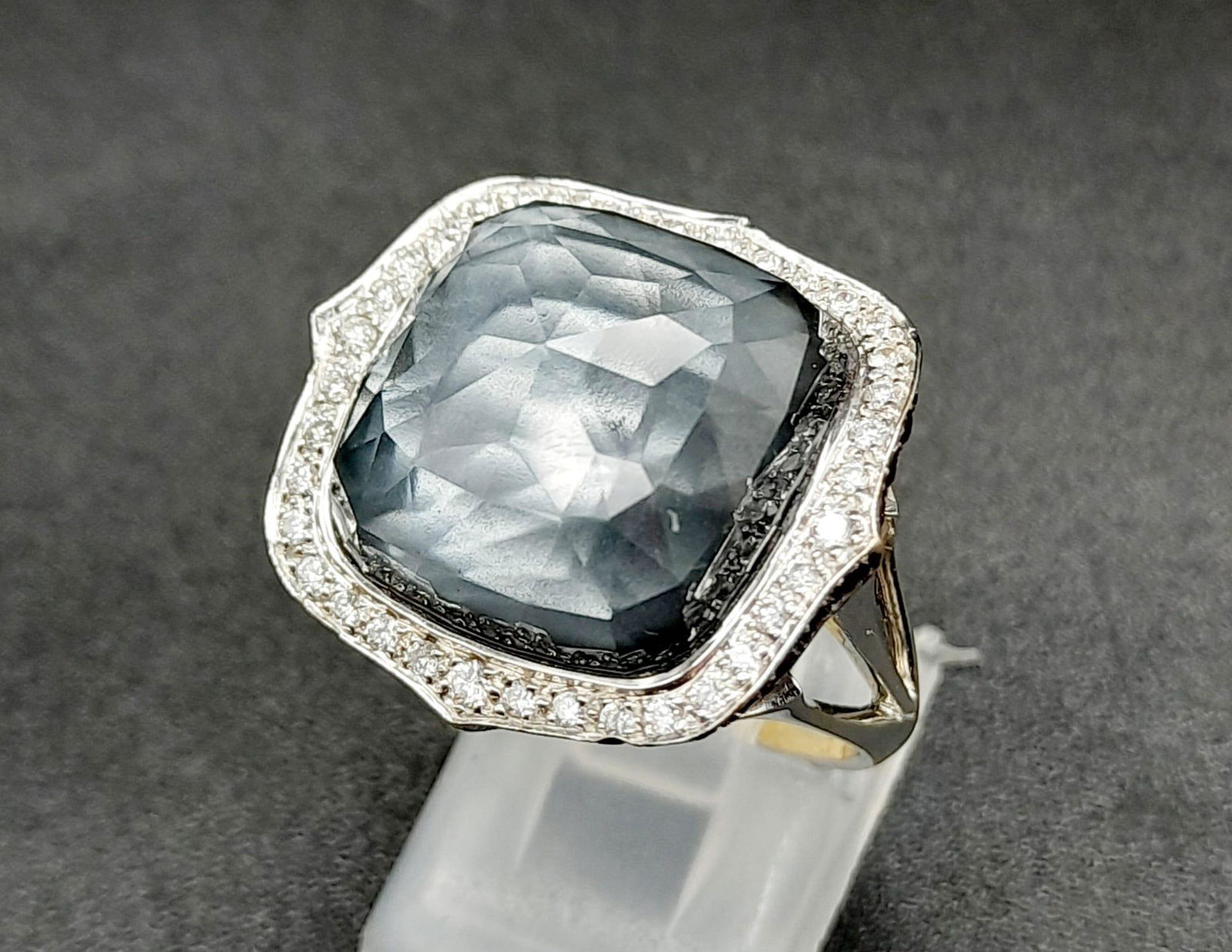 A Stephen Webster (designer) 18K White Gold, Diamond and Blue Haze Crystal Ring. Size M 1/2. 13.8g: A Stephen Webster (designer) 18K White Gold, Diamond and Blue Haze Crystal Ring. Size M 1/2. 13.8g total weight. Large pale blue quartz hematite with a diamond surround. Ref: 001596