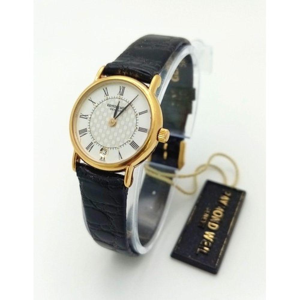 An 18K Gold Plated Raymond Weil Ladies Quartz Watch. Black leather strap. White checked dial. Gold: An 18K Gold Plated Raymond Weil Ladies Quartz Watch. Black leather strap. White checked dial. Gold plated case - 22mm. In very good condition and working order.