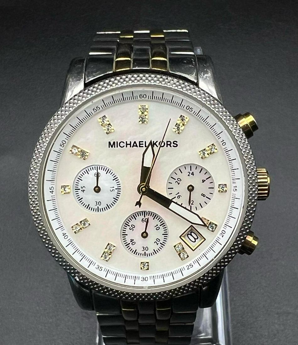 A Michael Kors Chronograph Ladies Watch. Stainless steel strap and case - 37mm. Mother of pearl dial: A Michael Kors Chronograph Ladies Watch. Stainless steel strap and case - 37mm. Mother of pearl dial with three sub dials and white stone decoration. In working order.