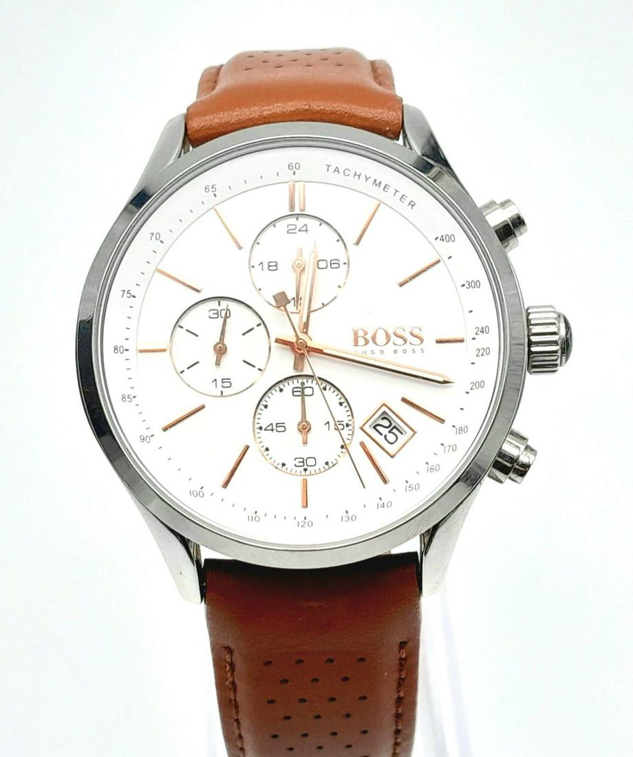 A Hugo Boss Chronograph Gents Watch. Brown leather strap. Stainless steel case - 44mm. White dial: A Hugo Boss Chronograph Gents Watch. Brown leather strap. Stainless steel case - 44mm. White dial with three sub dials. Quartz movement. In very good condition and working order. Comes with original c