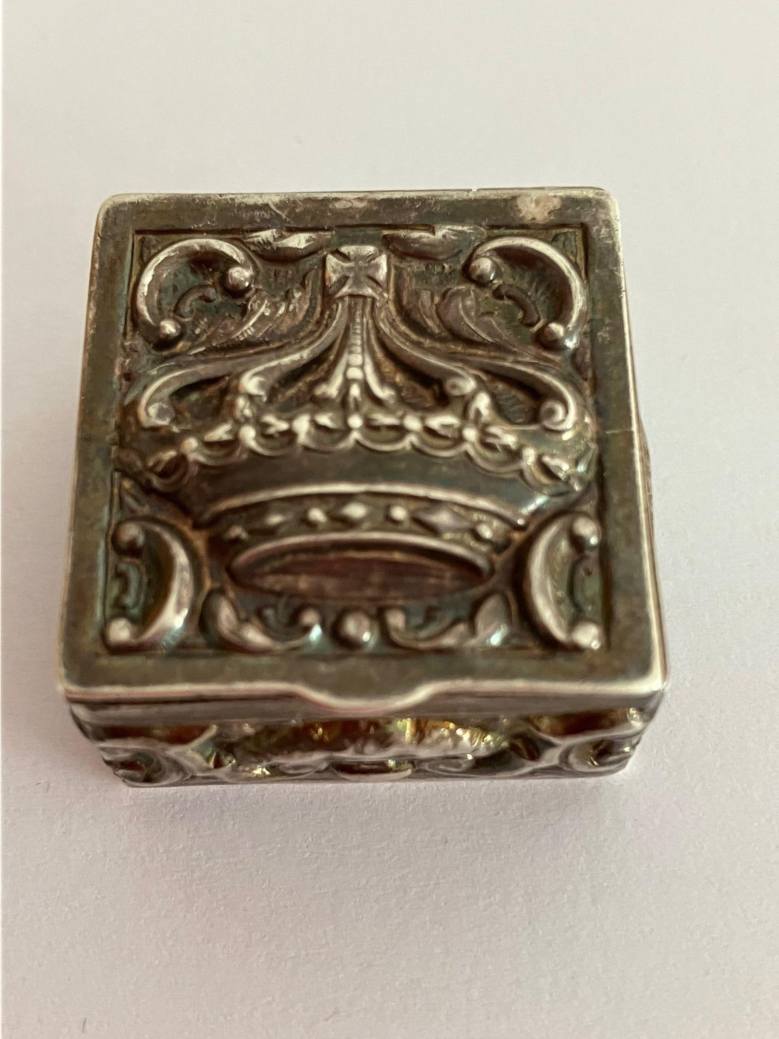 Vintage SILVER PILL BOX, Extremely unusual features having repousse Crown detail to lid with: Vintage SILVER PILL BOX, Extremely unusual features having repousse Crown detail to lid with repousse scroll pattern sides. Gilded interior. Full Hallmark to base. Excellent condition. 2.75 x 2.75 cm.