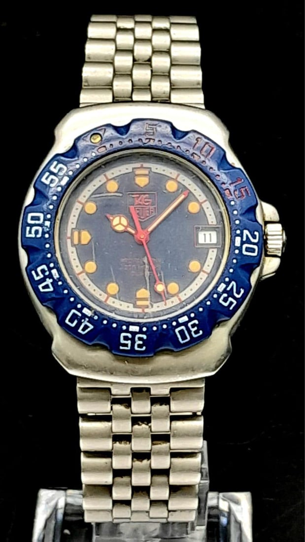 A Tag Heuer Professional 200 Metres Quartz Watch. Titanium strap and case - 35mm. Blue dial with: A Tag Heuer Professional 200 Metres Quartz Watch. Titanium strap and case - 35mm. Blue dial with date window. In working order. Comes with a WCSA paper. Ref: 14176