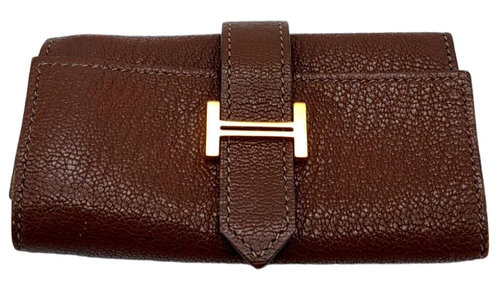 A Hermes Brown Bearn Key Case. Leather exterior and interior, with gold-tone logo hardware on outer: A Hermes Brown Bearn Key Case. Leather exterior and interior, with gold-tone logo hardware on outer flap. Four gold plated key holders. 10.5cm length x 6cm height. Please see photos for conditions. Re