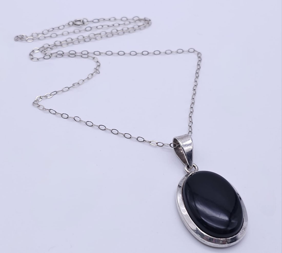 A Black Onyx Pendant Set in Silver on a Silver Chain. 4cm and 42cm.: A Black Onyx Pendant Set in Silver on a Silver Chain. 4cm and 42cm.