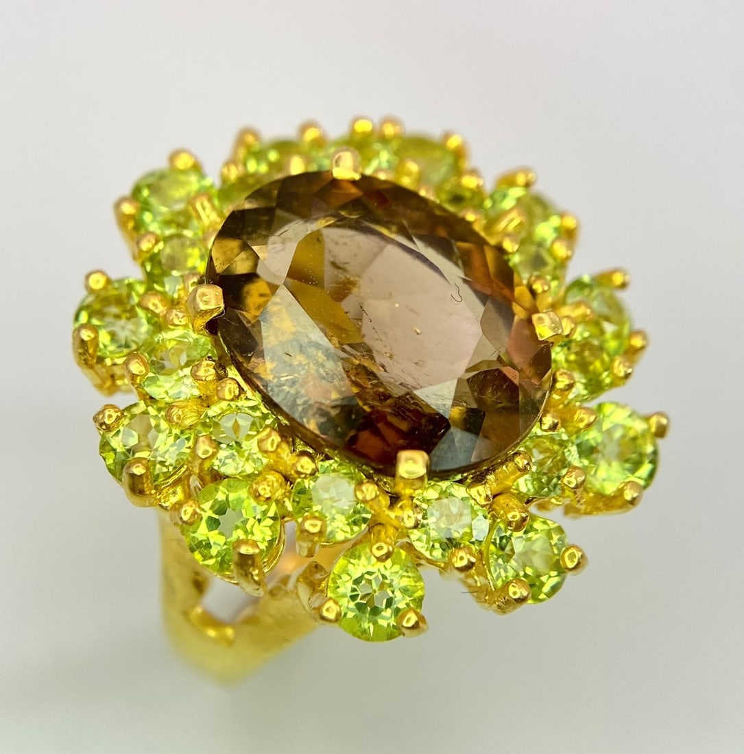 A truly magnificent, heavily gilded, sterling silver ring with a large, colour changing, oval cut: A truly magnificent, heavily gilded, sterling silver ring with a large, colour changing, oval cut Alexandrite surroundedby a halo of brilliant cut Peridots. Presented in a modern box, ring size: Q, we
