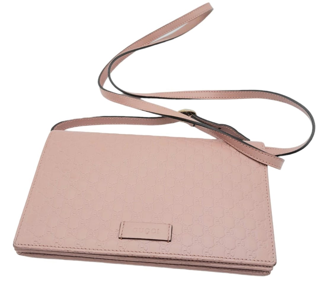 A Gucci Dusty Pink Monogram Crossbody Bag. Leather exterior, with a zipped outer pocket and a: A Gucci Dusty Pink Monogram Crossbody Bag. Leather exterior, with a zipped outer pocket and a detachable, adjustable strap so that the bag can be carried as a clutch. Leather and canvas interior, with