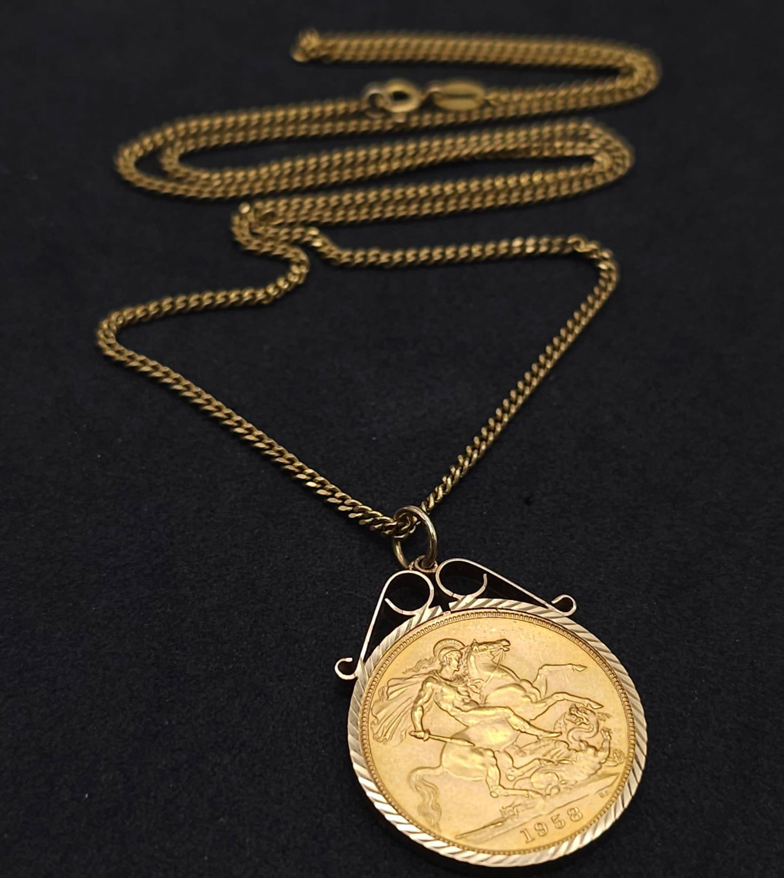 A 1958 GOLD SOVEREIGN IN A 9K GOLD SETTING AND ON A 50cm GOLD CHAIN . 14.11gms: A 1958 GOLD SOVEREIGN IN A 9K GOLD SETTING AND ON A 50cm GOLD CHAIN . 14.11gms