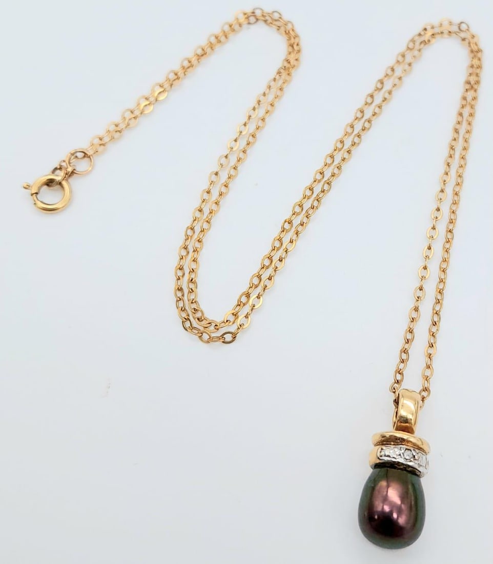 A BLACK TEAR DROP NATRAL PEARL PENDANT ON A 44cms 9K GOLD CHAIN .3.4gms: A BLACK TEAR DROP NATRAL PEARL PENDANT ON A 44cms 9K GOLD CHAIN .3.4gms