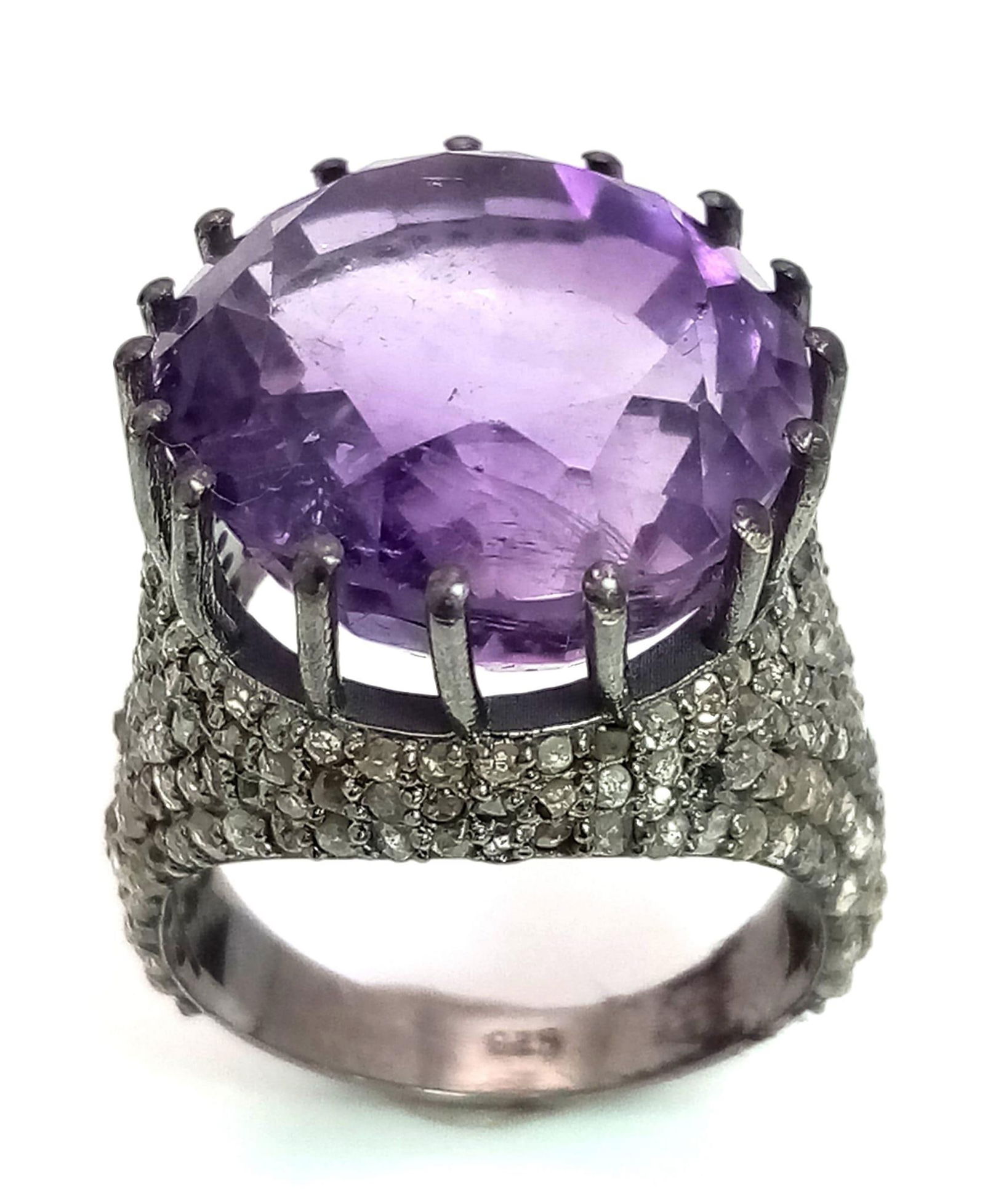 An Electrifying 17ct Amethyst with 2.20ct of Diamond Accents Ring. A beautiful round cut amethyst: An Electrifying 17ct Amethyst with 2.20ct of Diamond Accents Ring. A beautiful round cut amethyst with paved rose cut diamonds. Set in 925 silver. Size M/N. 8.46g total weight. Comes with a GLI certif