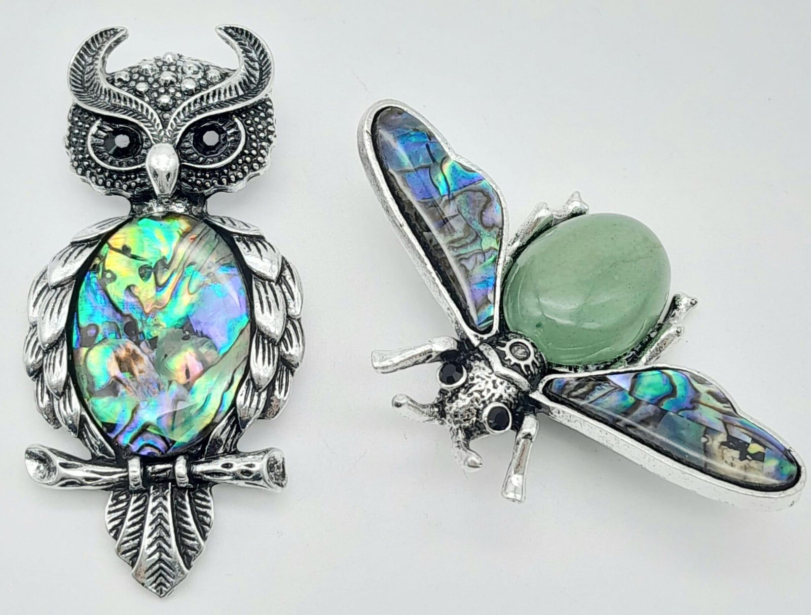 A Green Jade Bee and a Decorative Shell Owl Brooch - Both with blue stone eyes on decorative white: A Green Jade Bee and a Decorative Shell Owl Brooch - Both with blue stone eyes on decorative white metal. Bee - 5.5cm. Owl 6.5cm.