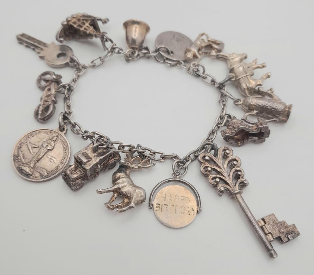A vintage sterling silver charm bracelet with multiple charms such as a palace, dragon ship, etc.: A vintage sterling silver charm bracelet with multiple charms such as a palace, dragon ship, etc. Total weight 41.5G. See photos for details.