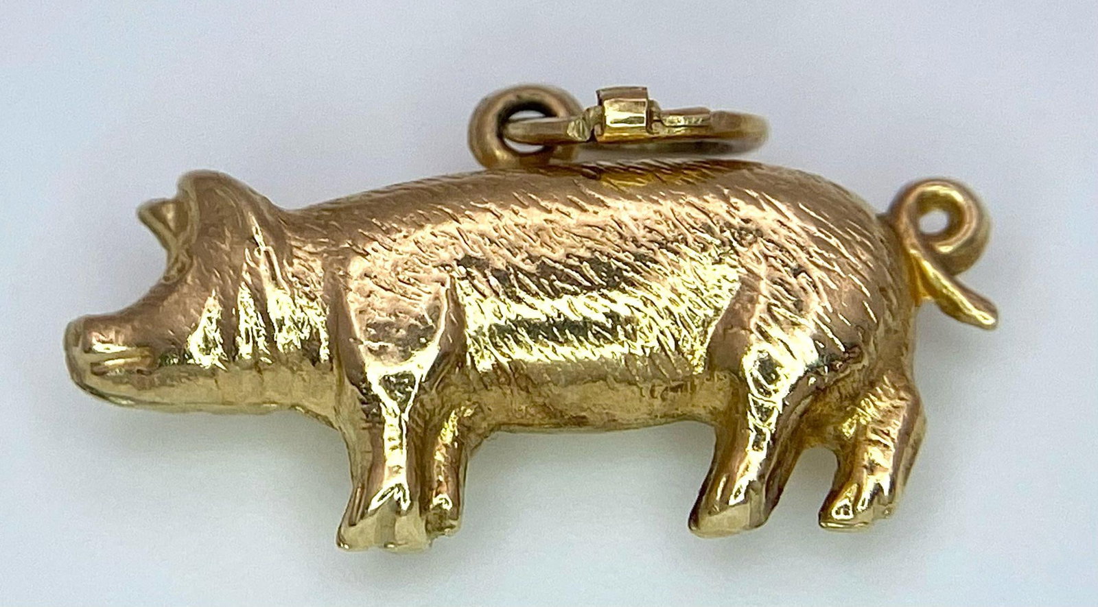 A 9K YELLOW GOLD PIG CHARM. TOTAL WEIGHT 0.8G: A 9K YELLOW GOLD PIG CHARM. TOTAL WEIGHT 0.8G