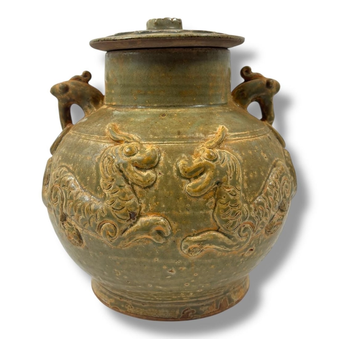 An Antique Asian Celadon-Glazed ceramic Jar with Lid. Beautiful olive-green celadon glaze, decorated: An Antique Asian Celadon-Glazed ceramic Jar with Lid. Beautiful olive-green celadon glaze, decorated in relief with opposing qilin motifs and dragon-shaped ring handles on each side, topped with a lot