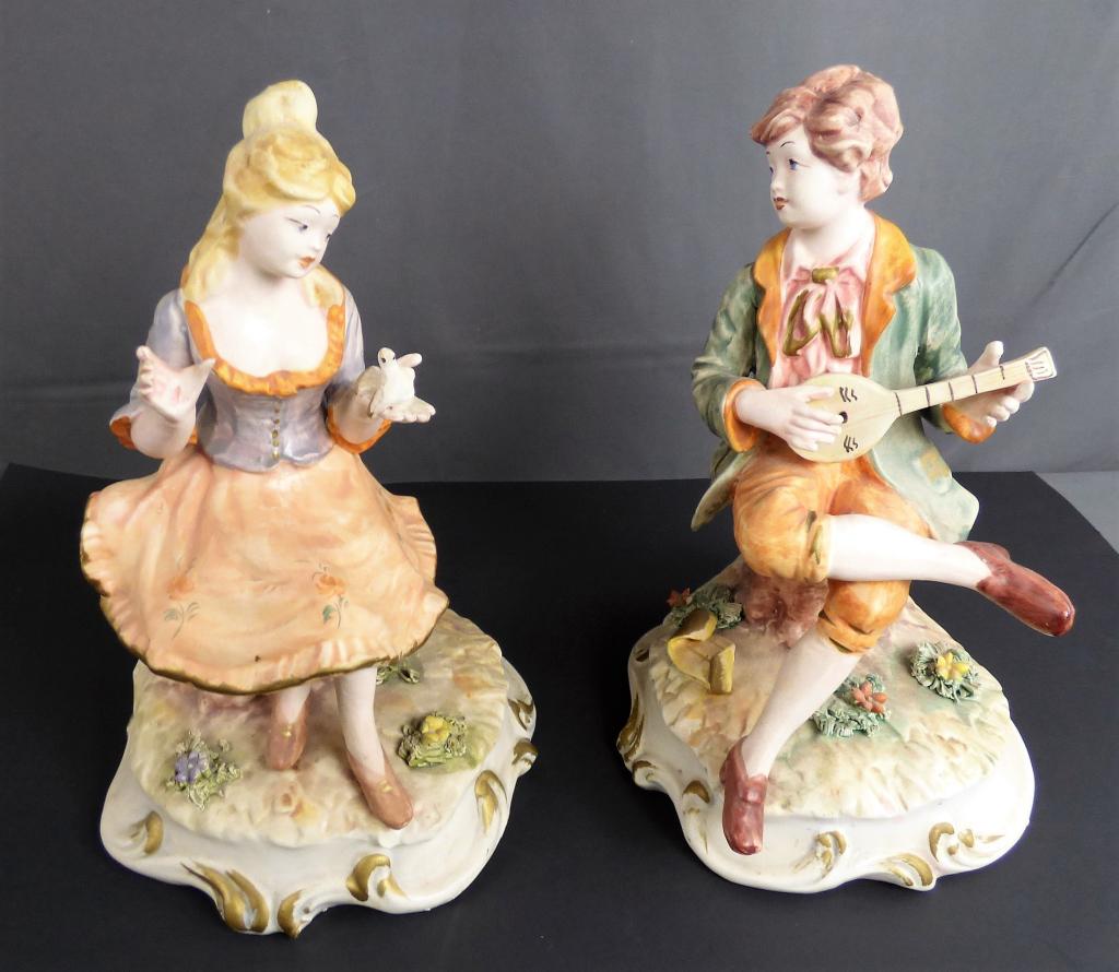 Capodimonte Italian Boy and Girl Figurines: Capodimonte Italian Boy and Girl Figurines. Measure 11 1/2" tall. Condition: Girls hand has repair