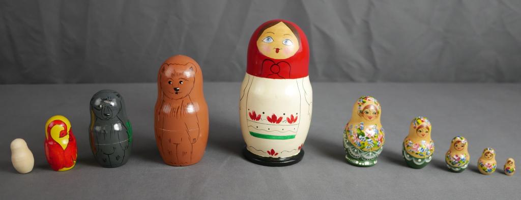 Russian Wooden Nesting Dolls- Two Sets: Two Sets of Russian Folk Wooden Nesting Dolls. One is Signed by artist and other has label "Made in Russia". Tallest Dolls measure 6" and 3" tall. Condition: Good