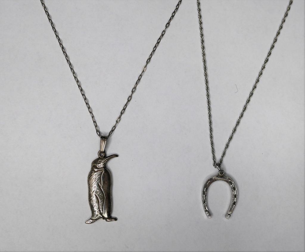 Sterling Silver Necklaces w/ Figural Pendants: Two adorable sterling silver necklaces. Penguin pendant stands proud on a 16" sterling chain; a lucky horseshoe by CW Sterling rests on an 18" chain. Both necklaces are in excellent condition.