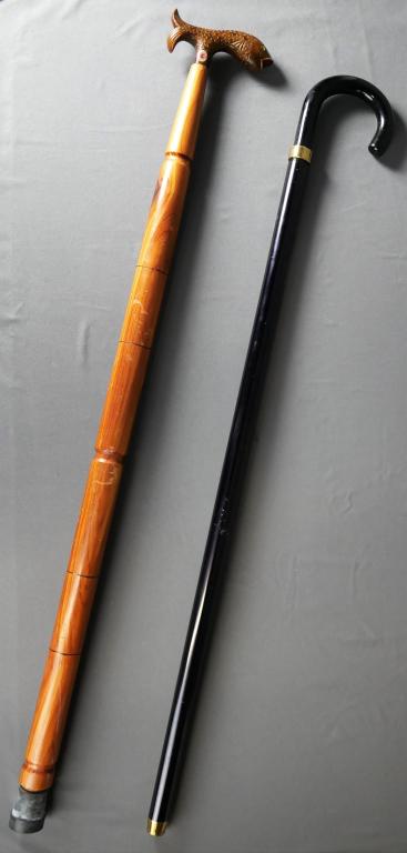 Two Walking Canes/ Sticks- Hidden Flask, Fish Hand: Two Canes/ Walking Sticks. One is with Wood Carved Fish Handle (made in Italy). Second - "Brandy Smuggler" with hidden glass flasks. Measure 37" & 38" long. Good Condition.