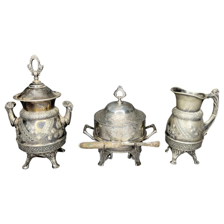 Antique Silverplate Butter Dish, Ornate Ewer & Urn: Antique Covered Butter Dish by Pairpoint Mfg; Highly Ornate Ewer and Covered Unr on Feet by Meriden B Company. Measure 11"-8" tall. Good overall condition, minor age related wear.