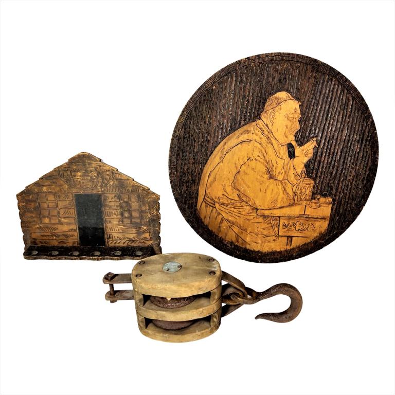 Pyrography Art- Pipe Rack & Large Barn Pulley: Pyrography Monk with Stein Round Wall Plaque; Pyrography Log Cabin Pipe Holder dated 1905 and Antique Large Wooden Barn Pulley- marked "US Govt. D.P.C.". Plaque is 18" in diameter; Pipe Holder is 13" 
