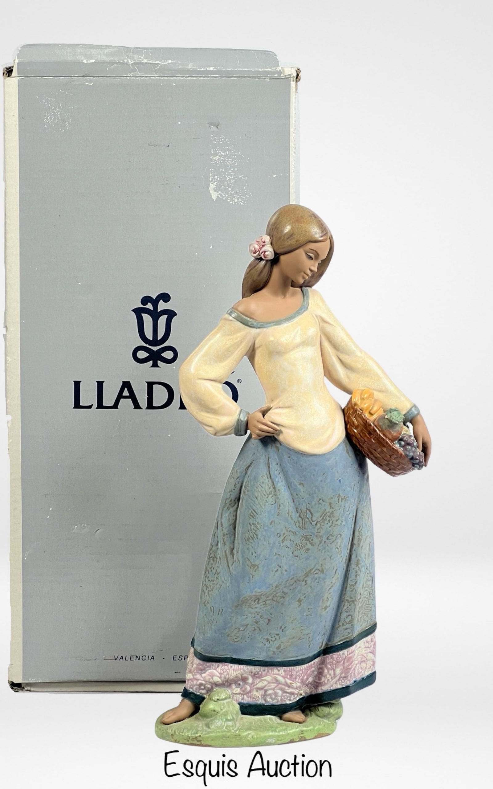 Lladro- "Seasonal Gifts" 2229 Porcelain Figurine: Presenting the Lladro "Seasonal Gifts" 2229 Porcelain Figurine, standing at an impressive 17 inches tall. This exquisite piece captures the artistry and craftsmanship that Lladro is renowned for. Deli