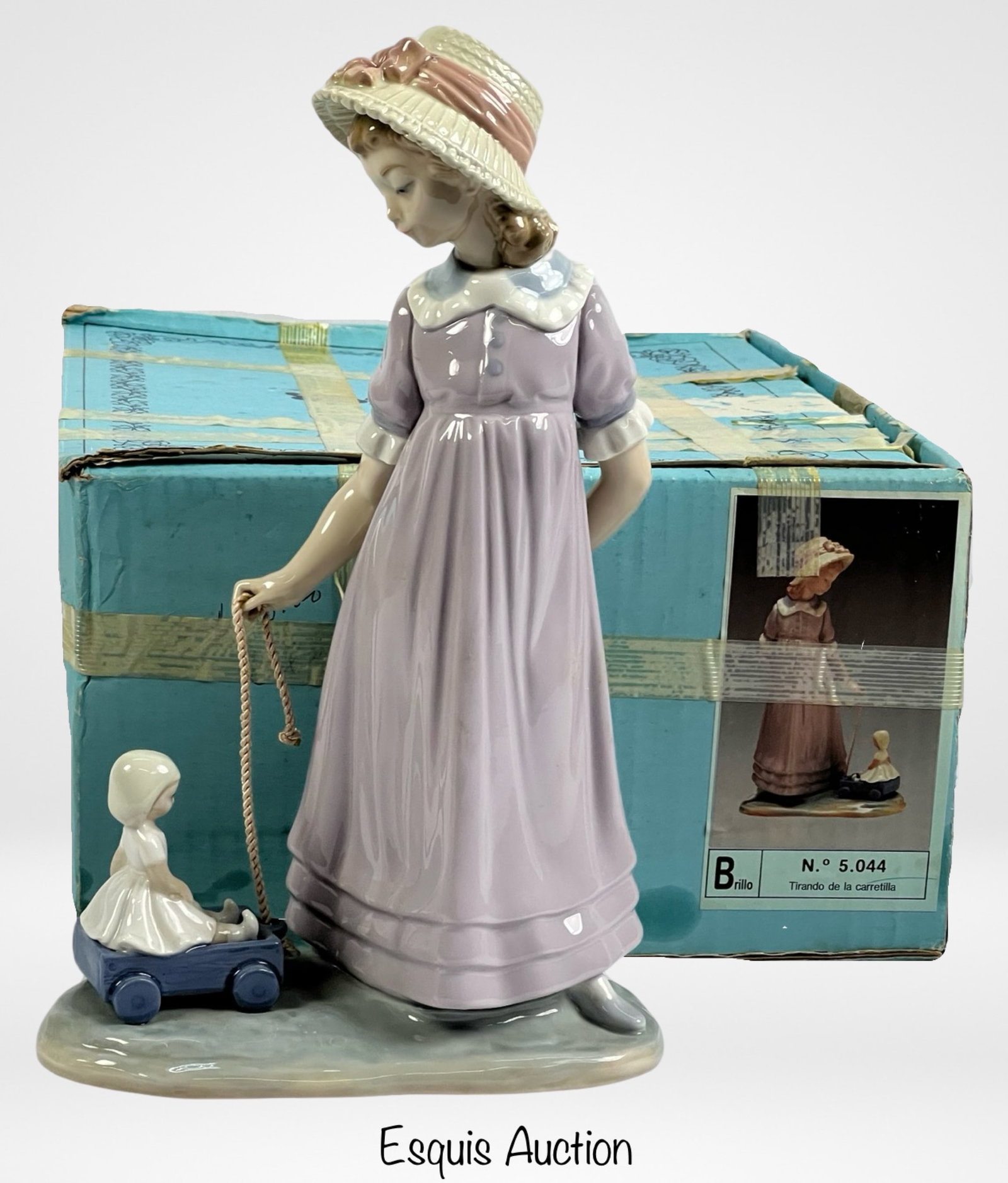 Lladro Girl Pulling Doll Carriage Figurine 5044: Experience the charm of childhood captured in the Lladro "Girl Pulling Doll Carriage" Porcelain Figurine. With a delightful size of 11" x 7", this figurine, numbered 5044, portrays a whimsical moment 