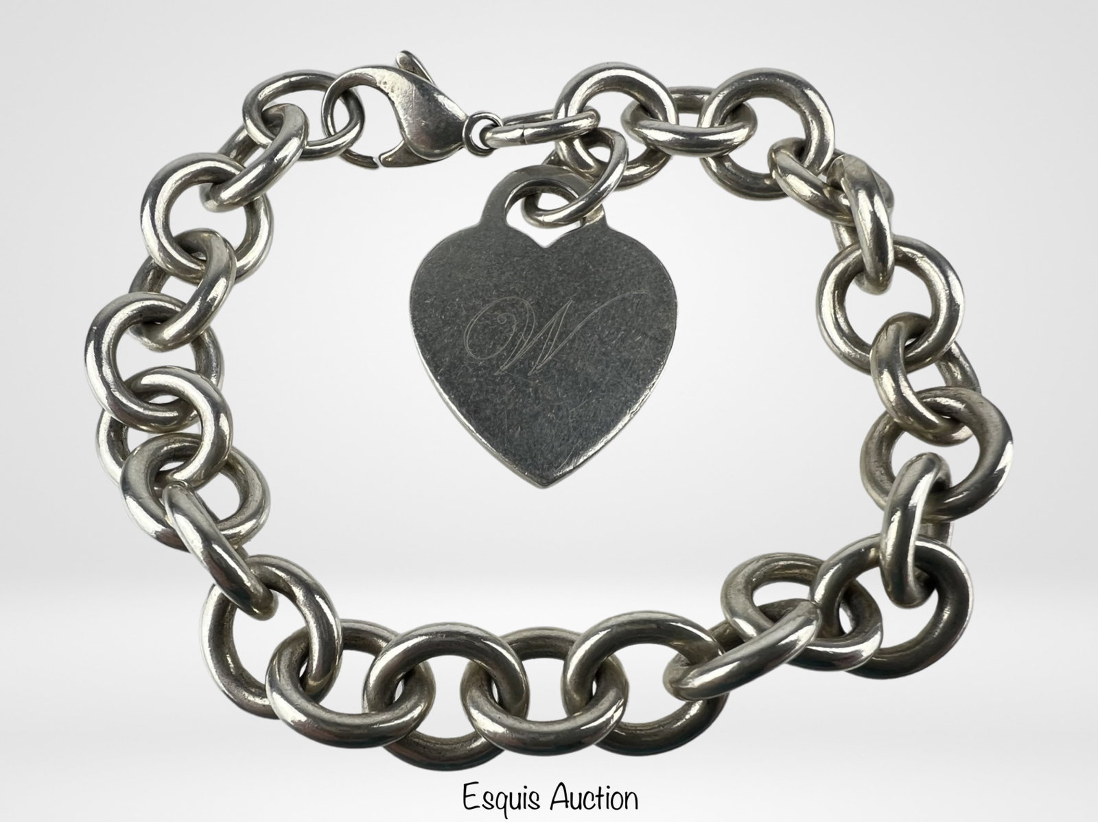 Tiffany & Co Heart Charm/ Tag Bracelet: Elevate your style with the timeless elegance of the Tiffany & Co. Sterling Silver Heart Charm Bracelet. This bracelet, measuring 7 1/2 inches in length, is a symbol of sophistication and classic beau