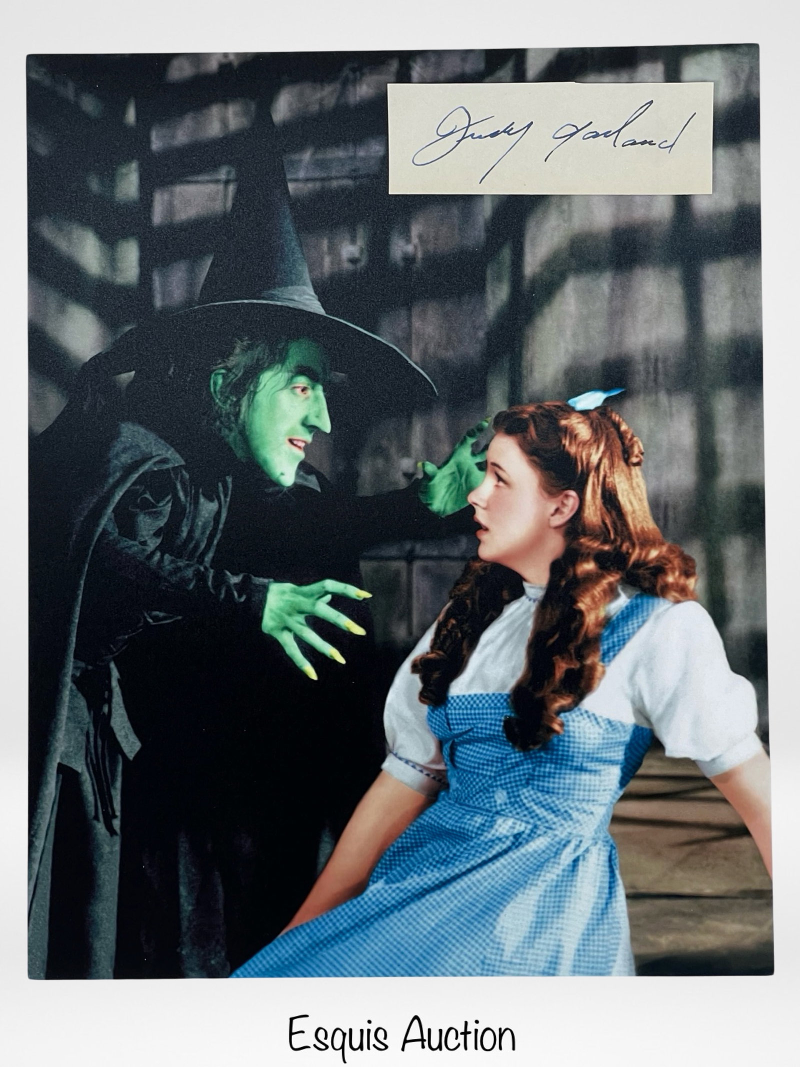 Judy Garland Autograph w/ Wizard of Oz Photo: Capture the magic of "The Wizard of Oz" with this Judy Garland Autograph paired with an iconic 8" x 10" photograph. The legendary Judy Garland, known for her unforgettable portrayal of Dorothy in the 