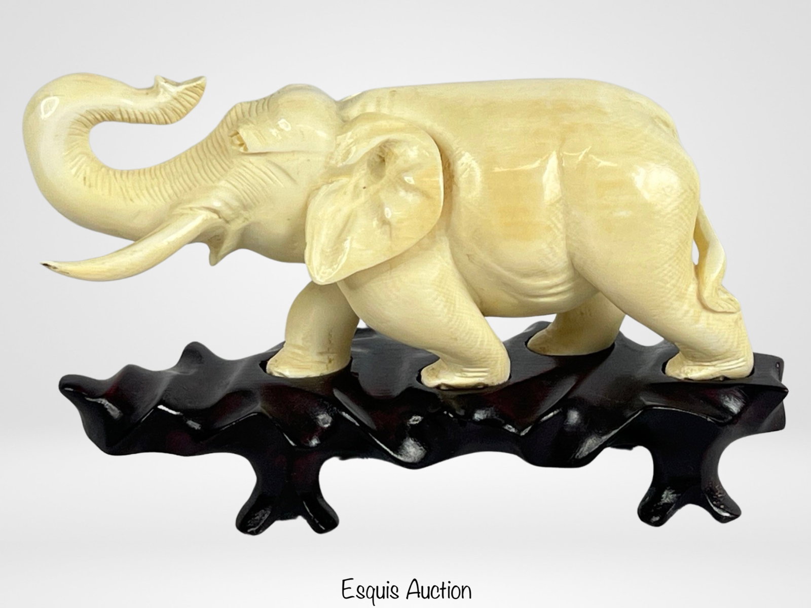 Oriental Bone Carved Elephant Sculpture: Introducing a captivating vintage Oriental iv*ry bone carved elephant sculpture, elegantly displayed on a wooden base.This exquisite sculpture, measuring 7 inches in height and 3 inches in width, show