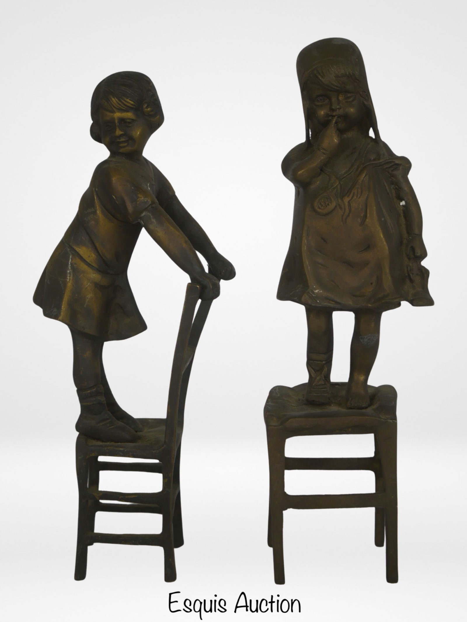 Juan Clara (after)- Pair of Girls on Chair/ Stools: Embrace the enduring charm of Juan Clara's artistic legacy with this exquisite pair of bronze sculptures. Standing gracefully at 11" tall, these sculptures beautifully capture the innocence and grace