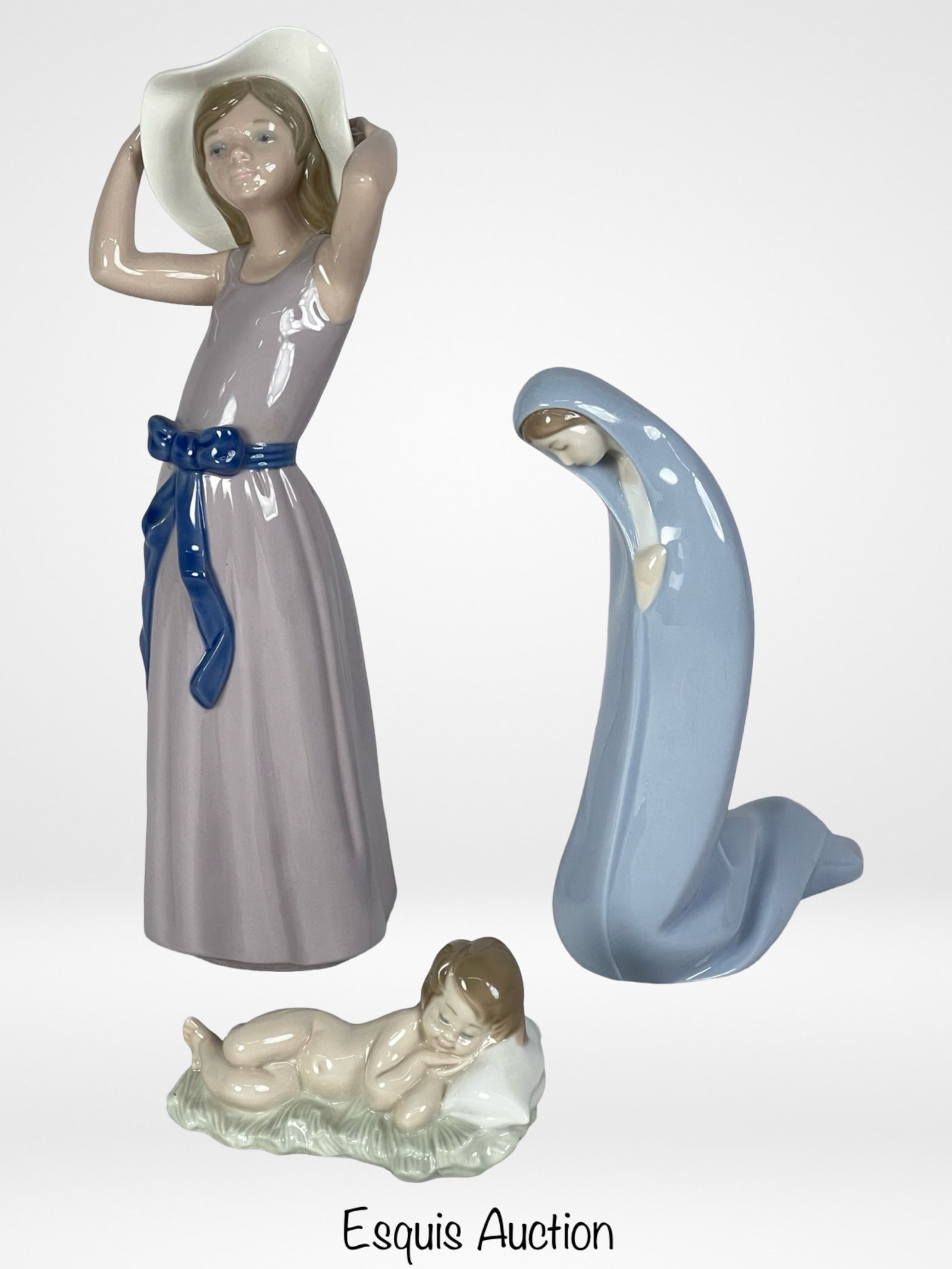 Lladro Porcelain Figurines: This exceptional collection features three exquisite Lladro porcelain figurines, each a testament to the brand's timeless elegance and meticulous craftsmanship. "Coy Girl with Straw Hat" 5011, "Baby J