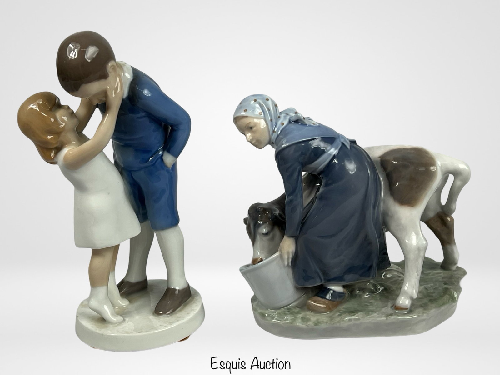 B&G and Royal Copenhagen Porcelain Figurines: B&G and Royal Copenhagen Porcelain Figurines- Boy & Girl Hugging by B&G 1781 and Girl with Cow by Royal Copenhagen 779. These figurines highlight the exceptional craftsmanship of two esteemed Danish p