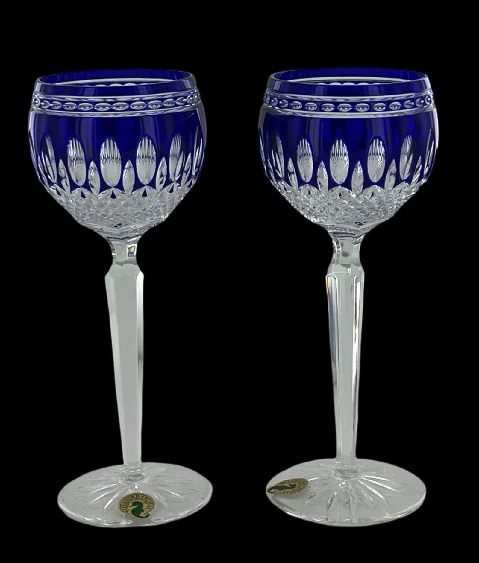 Waterford Crystal Clarendon Cobalt Wine Goblets: This exquisite pair of Waterford Crystal Clarendon Cobalt Hock Wine Glass Goblets epitomizes luxury and fine craftsmanship. Each goblet features a stunning cobalt blue bowl, intricately cut to enhance
