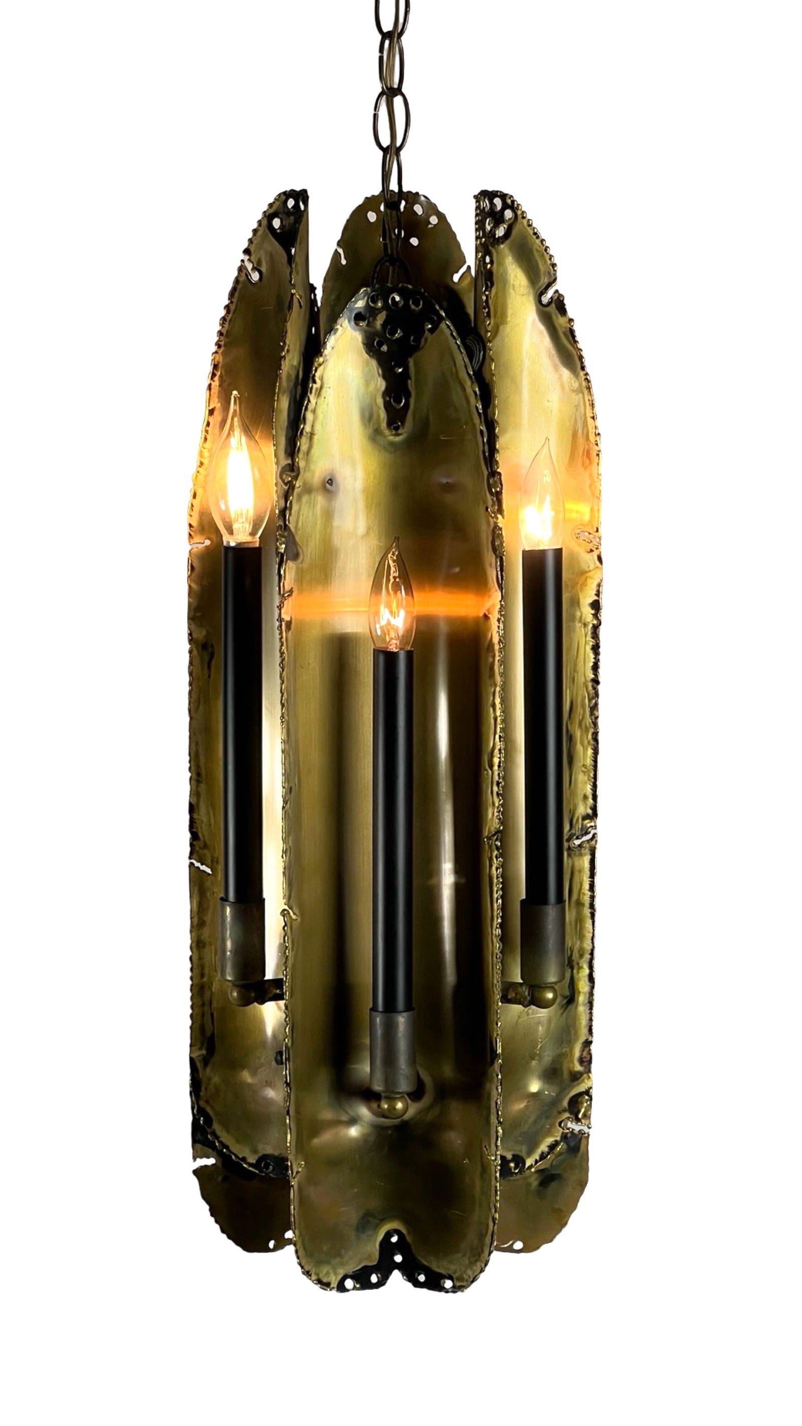 Brutalist Torch Cut Brass Light by Tom Green: Six-light Brutalist torch cut brass hanging pendant light / chandelier by Tom Greene for Feldman Lighting. 25" tall x 8" in dia. Good working condition with long cable.