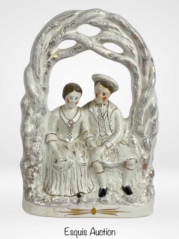 19th C Staffordshire Scottish Wedding Couple: Embark on a journey to the romantic landscapes of 19th-century Scotland with this exquisite Staffordshire porcelain figurine portraying a Scottish wedding couple. Standing as a testament to the enduri