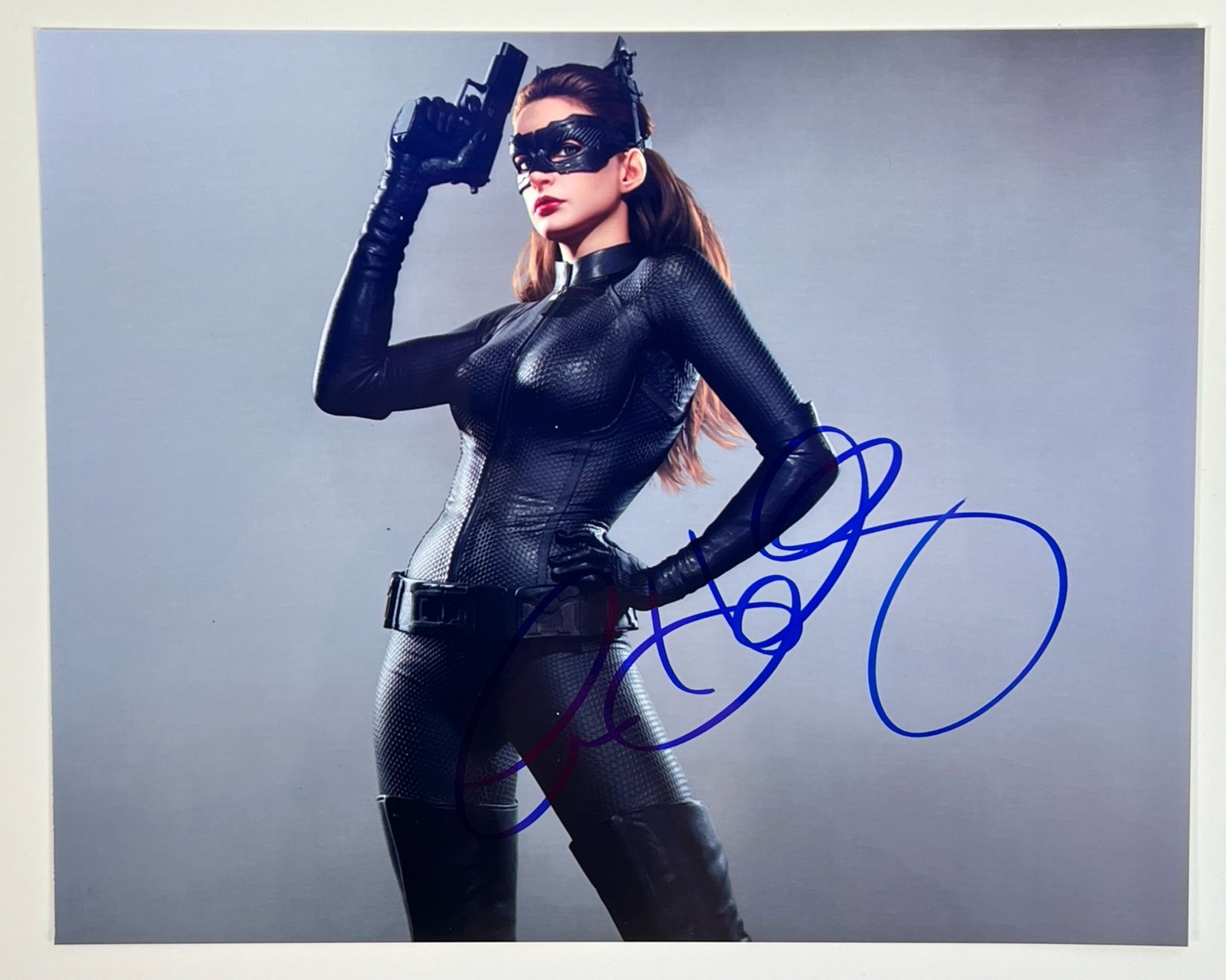 Anne Hathaway as Catwomen Autographed Photograph: This stunning collector's piece features Anne Hathaway as the iconic Catwoman in Christopher Nolan's "The Dark Knight Rises." The photograph captures Hathaway in her sleek, black Catwoman costume, exu