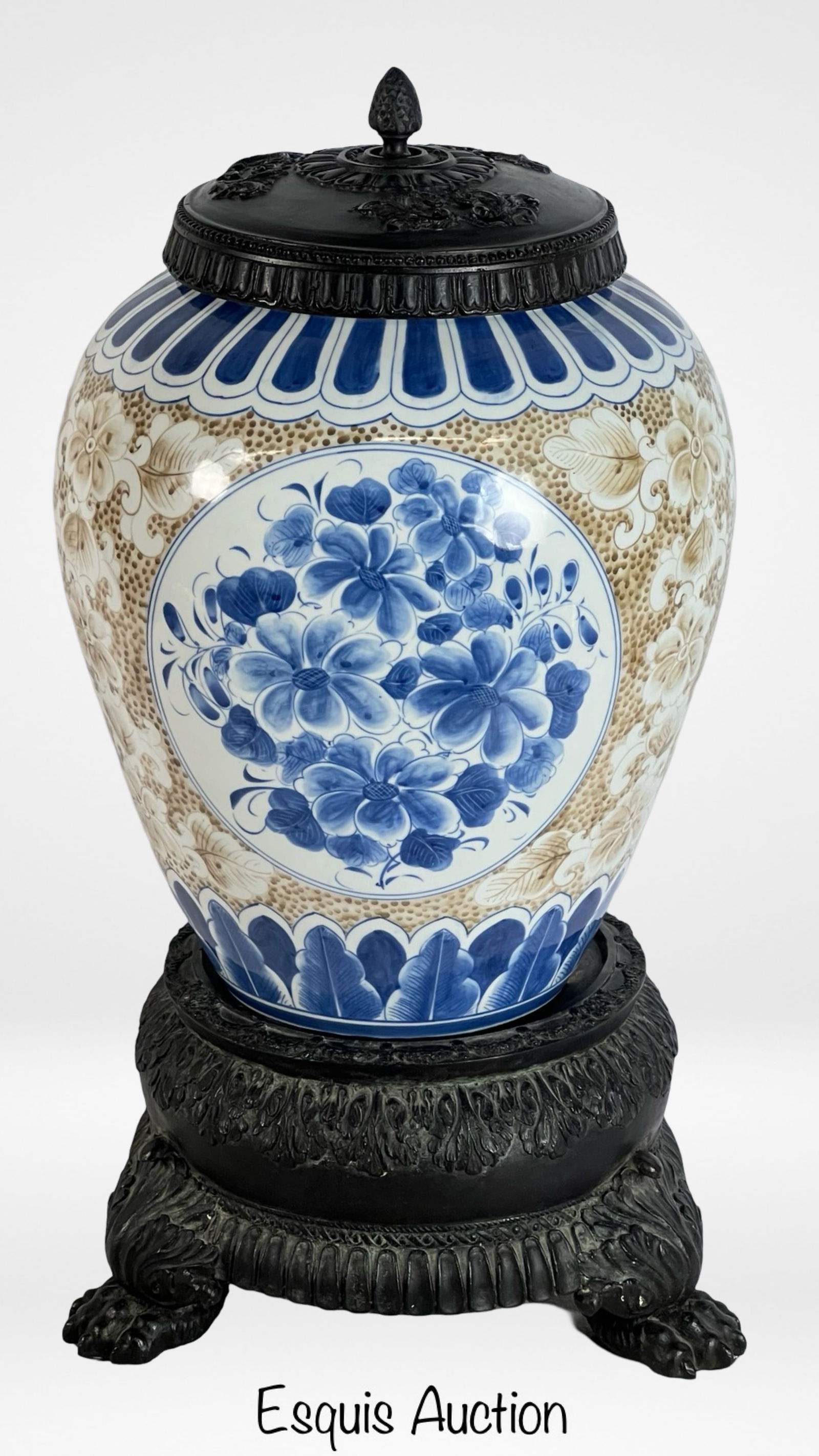 Maitland-Smith Lidded Jar on Ornate Bronze Stand: This elegant decorative piece from Maitland-Smith features a beautifully detailed lidded jar adorned with intricate blue and white floral patterns. The jar sits atop an ornate black bronze base with a