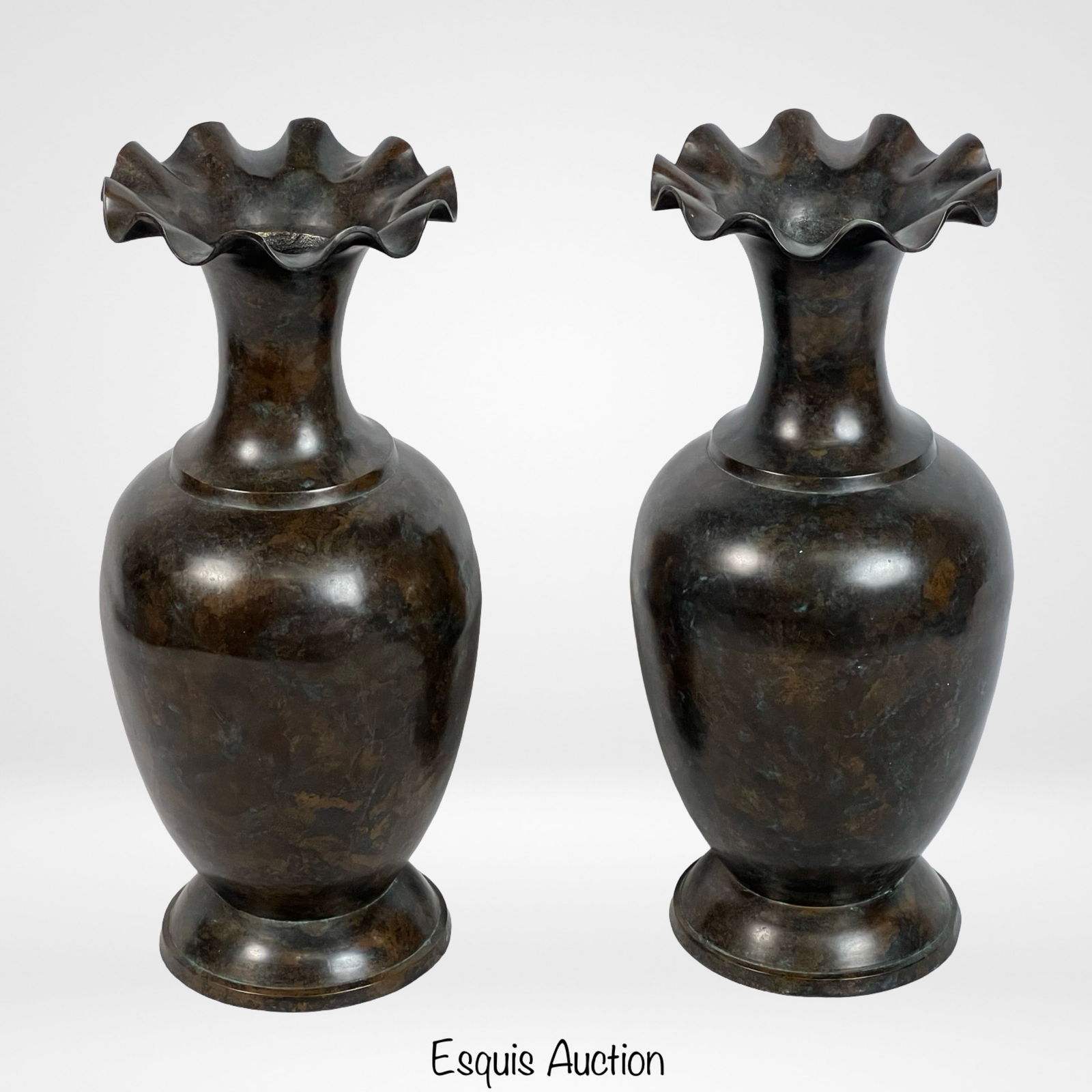 Pair of Maitland-Smith, Ltd Brass Verdi Vases: Pair of Maitland-Smith Ltd. brass verdi vases featuring a classic urn shape with flared, ruffled mouths. The vases exhibit a rich, dark patina, adding a touch of elegance and sophistication to any dec