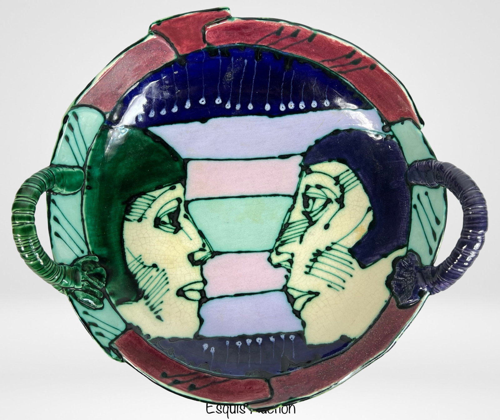 Rasa Saldaitis Ceramics Studio Centerpiece Bowl: This striking centerpiece bowl by Rasa Saldaitis features a vibrant and intricate design. The bowl showcases two profile faces in a colorful abstract composition on the interior, framed by bold geomet