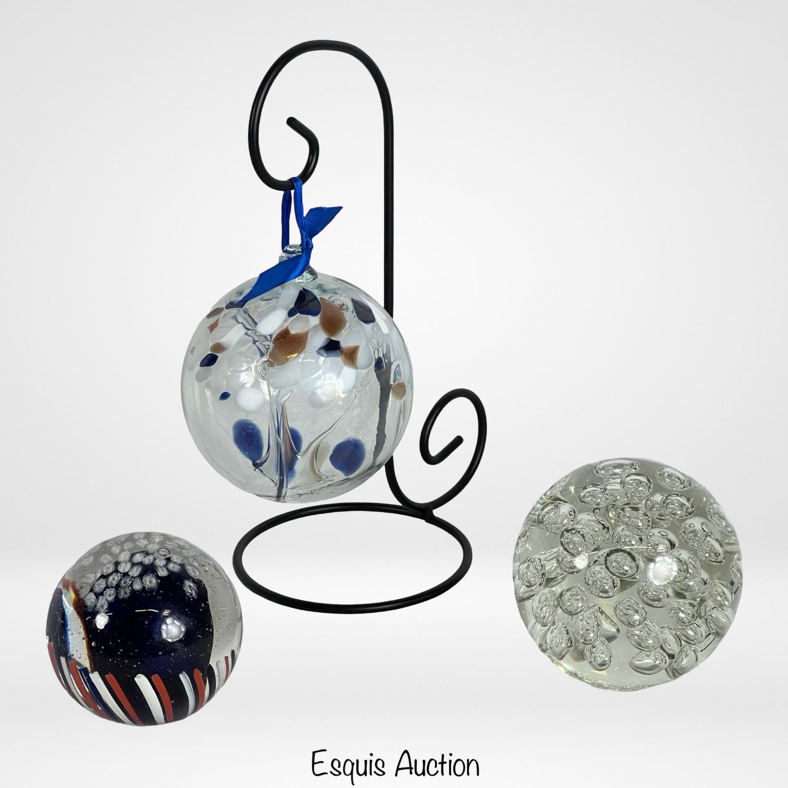 Oversized Art Glass Paperweights & Witch Ball: This lot includes a Kitra's blown art glass witch ball, complete with a metal stand, and two oversized glass paperweights. One is Signed Brian S. 1999. Tallest is 6", paperweights ar approx. 5" in dia