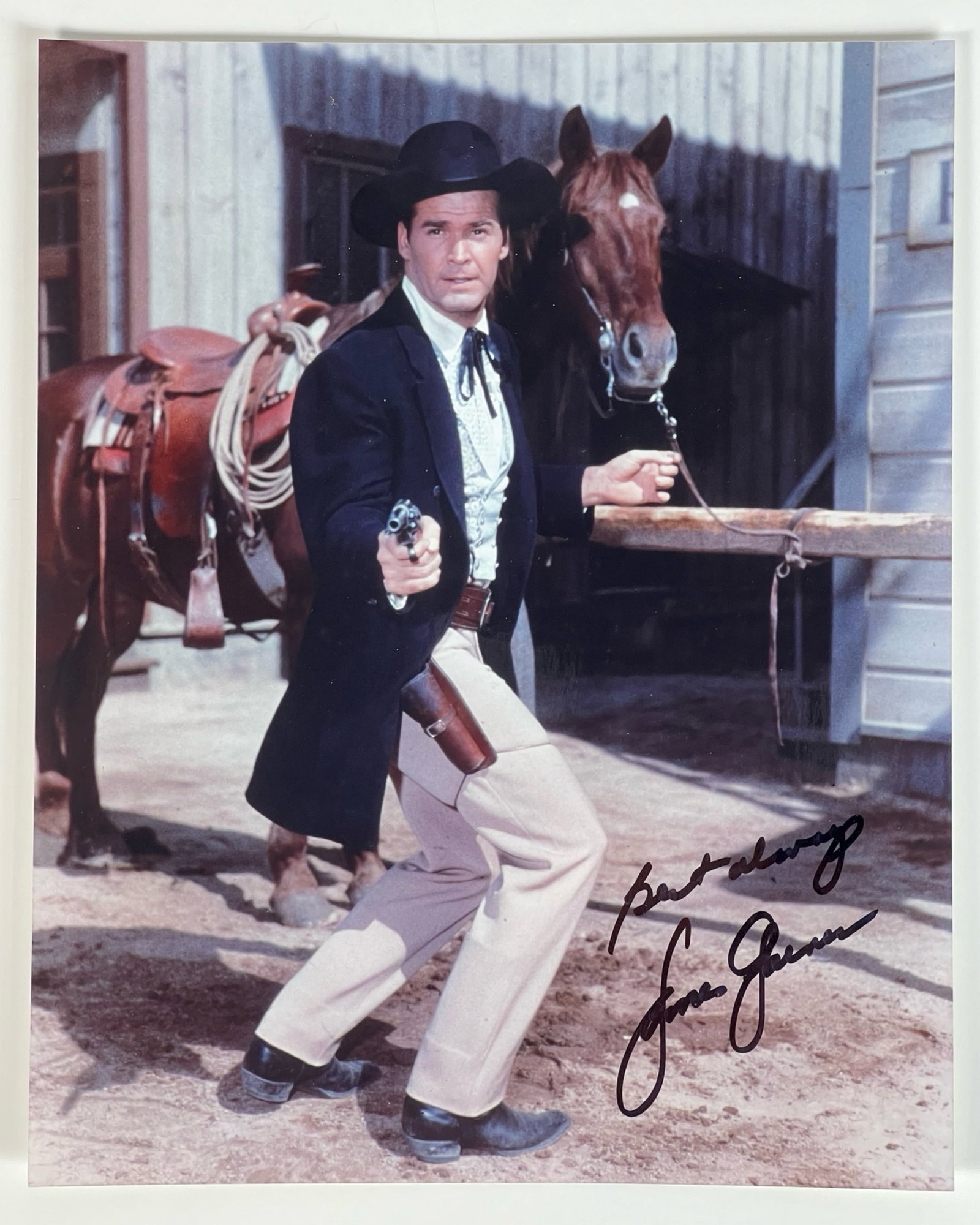 James Garner Autographed/ Signed Photograph: A striking photograph featuring the legendary actor James Garner in a classic Western pose. Garner is depicted standing in front of a horse, gun in hand, fully embodying the rugged charm and tough per